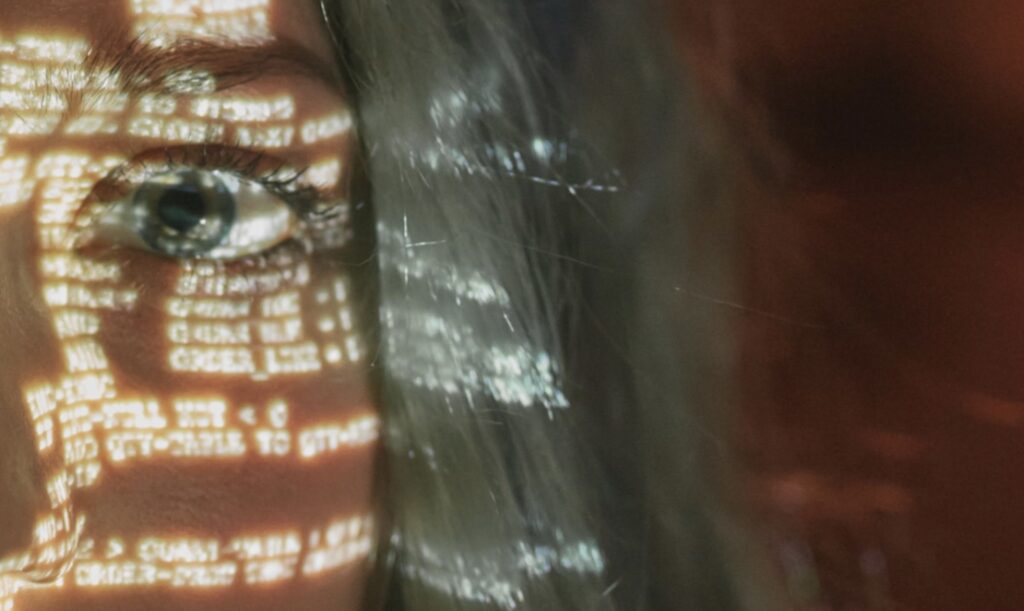 Lignes de code projetées sur un visage, près de l’œil